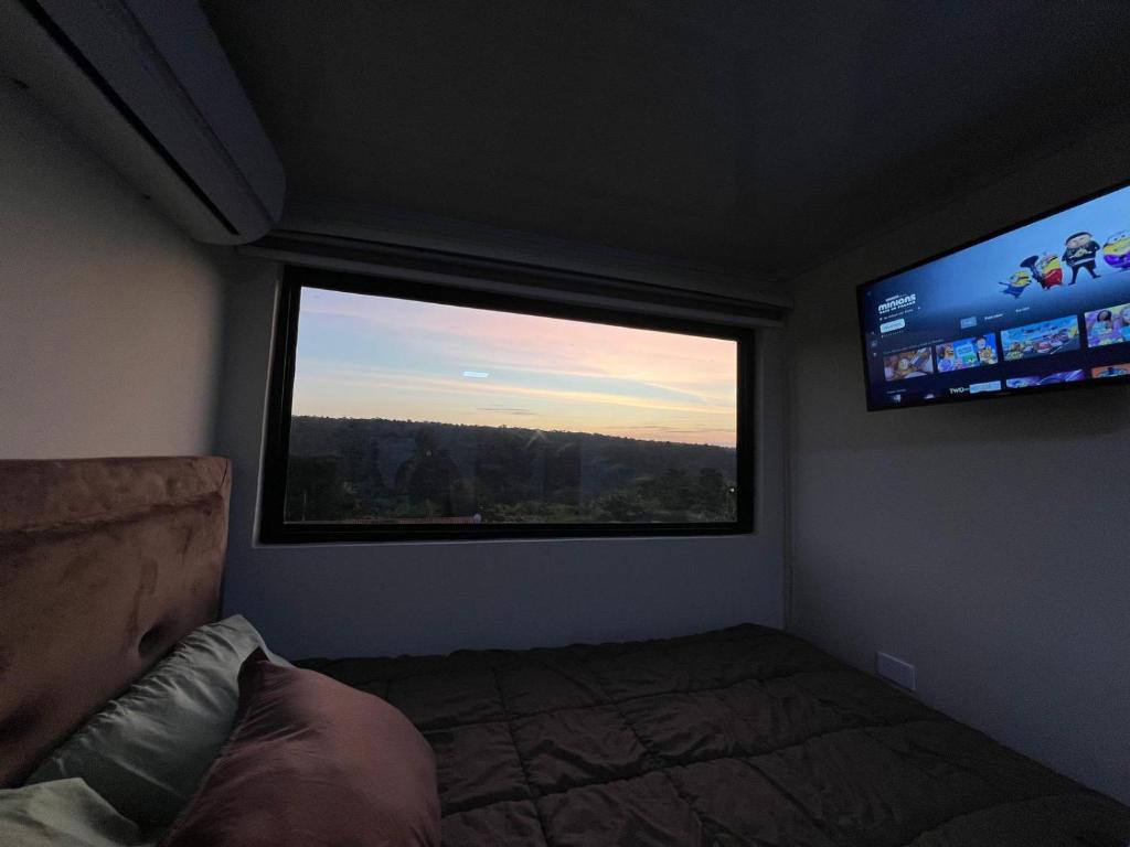 a bedroom with a bed and a large window at Container Home Py in Puerto Presidente Franco