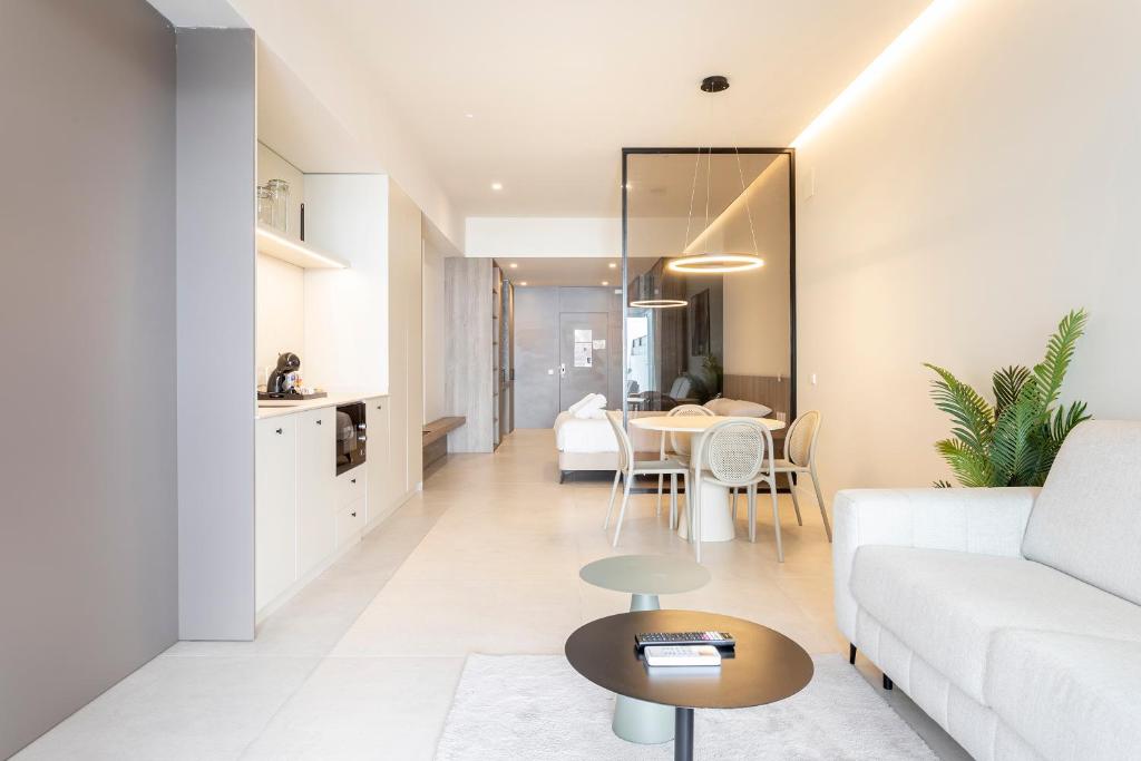a living room with a white couch and a table at North Station PEN-SUITES in Valencia