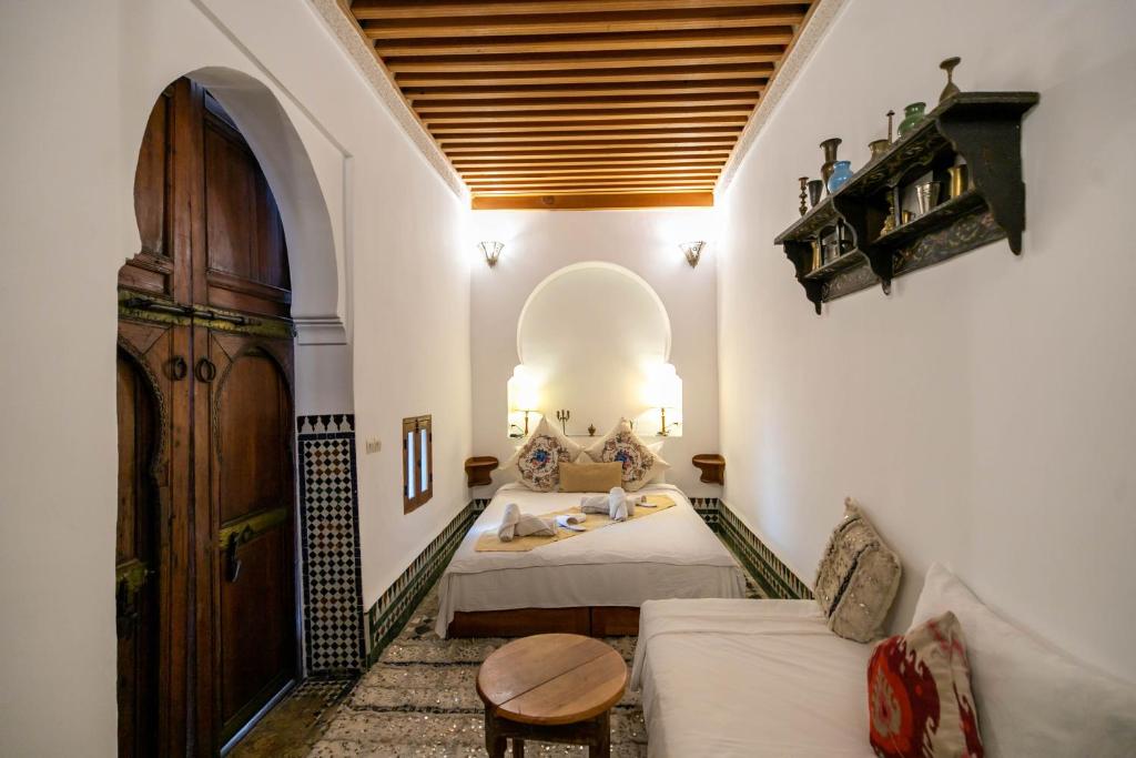 una camera con due letti e una porta in legno di Dar Authentic Fes - familly hosting a Fes