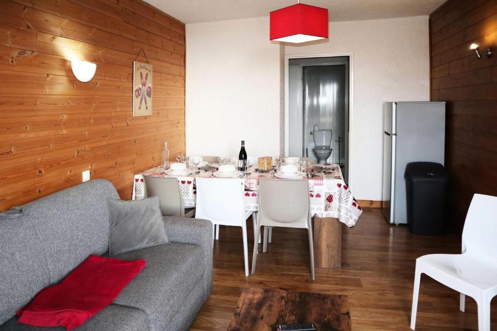 un salon avec un canapé et une table avec des chaises dans l'établissement Residence Le 1650 - Appartement pour 8 personnes cœur de station MAE-5901, aux Orres