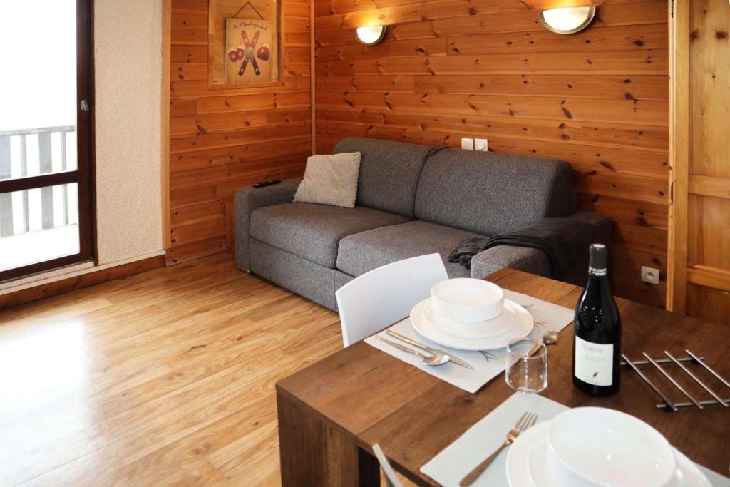 un salon avec un canapé et une table dans l'établissement Residence Le 1650 - Studio pour 2 personnes cœur de station MAE-5911, aux Orres