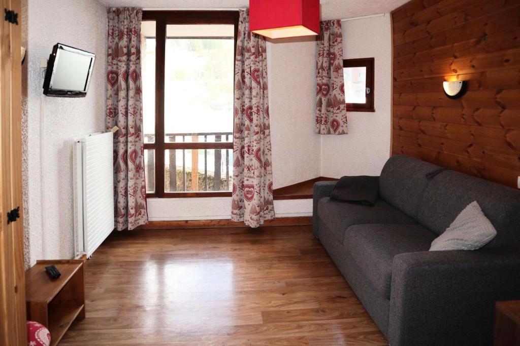 un salon avec un canapé et une fenêtre dans l'établissement Residence Le 1650 - Studio pour 2 personnes cœur de station MAE-5951, aux Orres