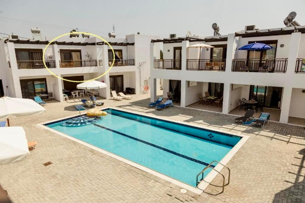 an apartment with a swimming pool in front of a building at Harmonia at Gennadi Court in Gennadi