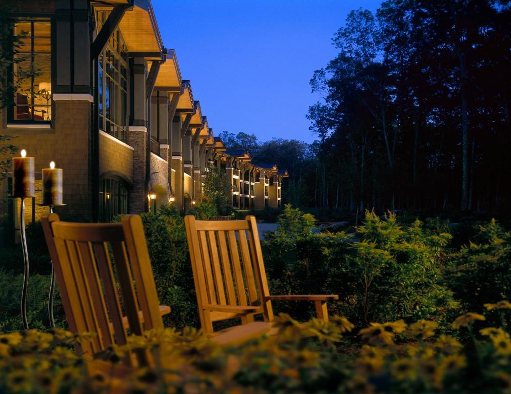two chairs sitting in front of a building at night at The Lodge at Woodloch in Hawley