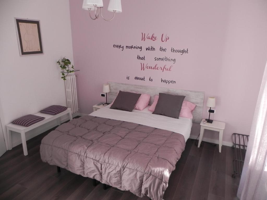 ein Schlafzimmer mit einem Bett mit einem Zitat an der Wand in der Unterkunft Vica Pota in Rom