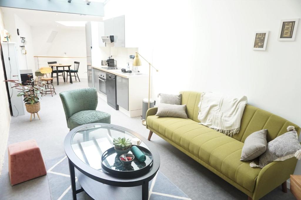 un salon avec un canapé vert et une table dans l'établissement Beautiful duplex with AC - Place du Palais, à Bordeaux