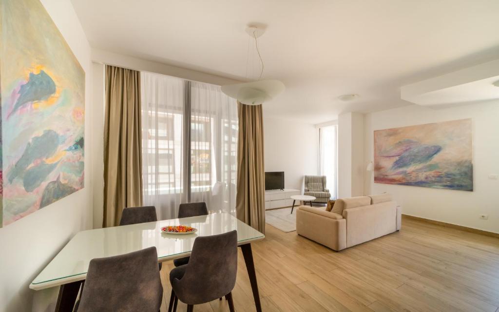 ein Wohnzimmer mit einem Esstisch und einem Sofa in der Unterkunft Amare Luxury Apartments in Budva