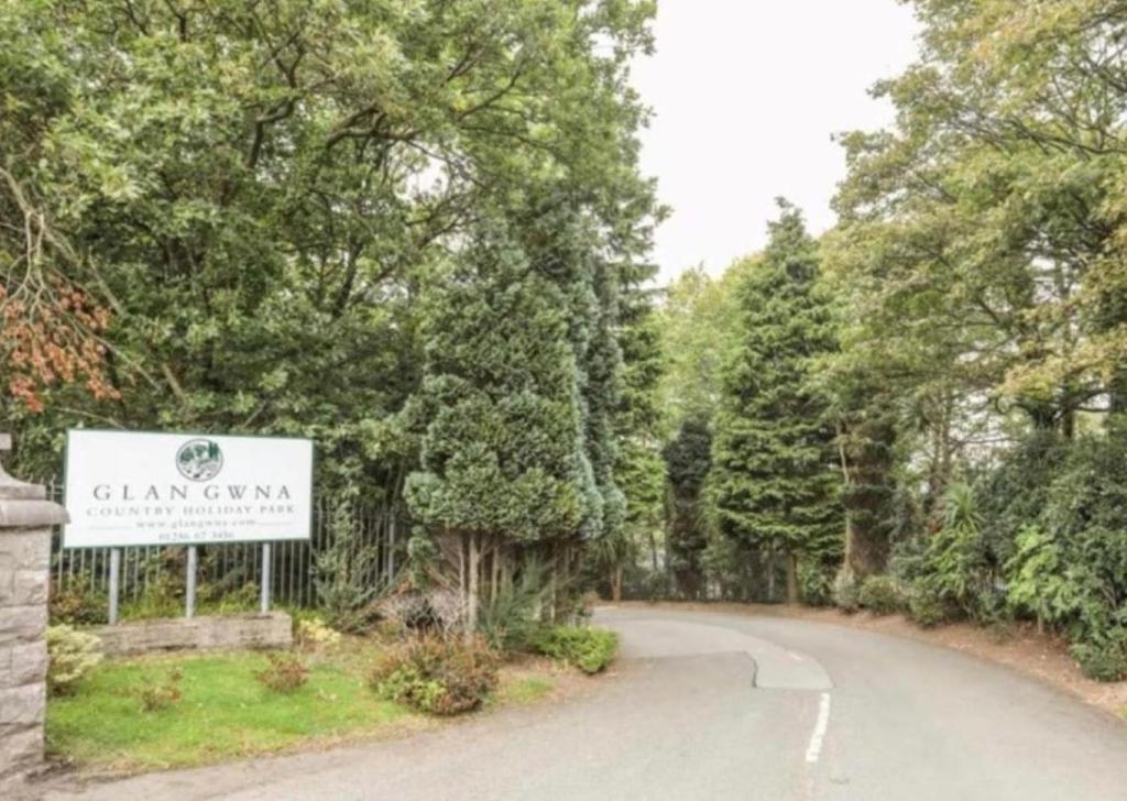 a road with a sign in the middle of a forest at Betty’s Hideaway in Caernarfon