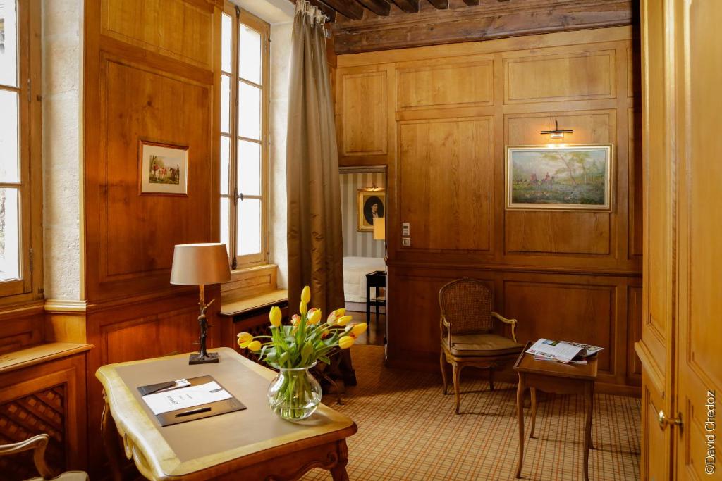 une chambre avec un vase de fleurs sur une table dans l'établissement La Cour Berbisey - Teritoria, à Dijon