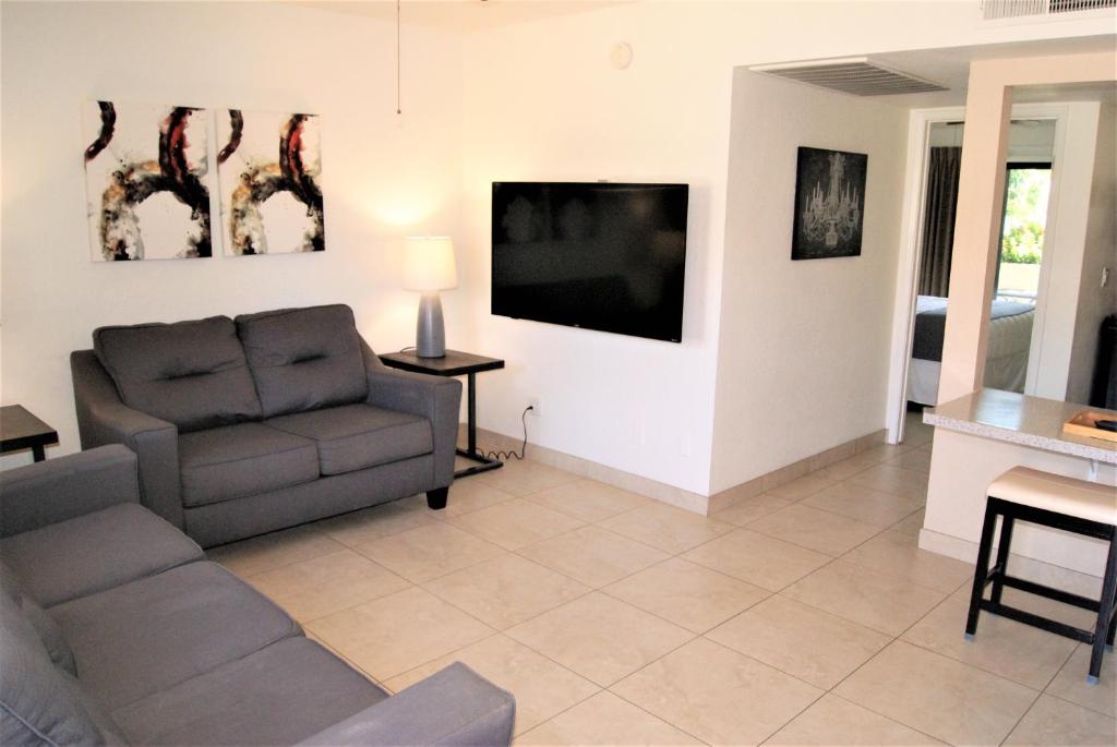 sala de estar con sofá y TV de pantalla plana en 114 Fully Furnished 1BR Suite-Prime Location, en Scottsdale