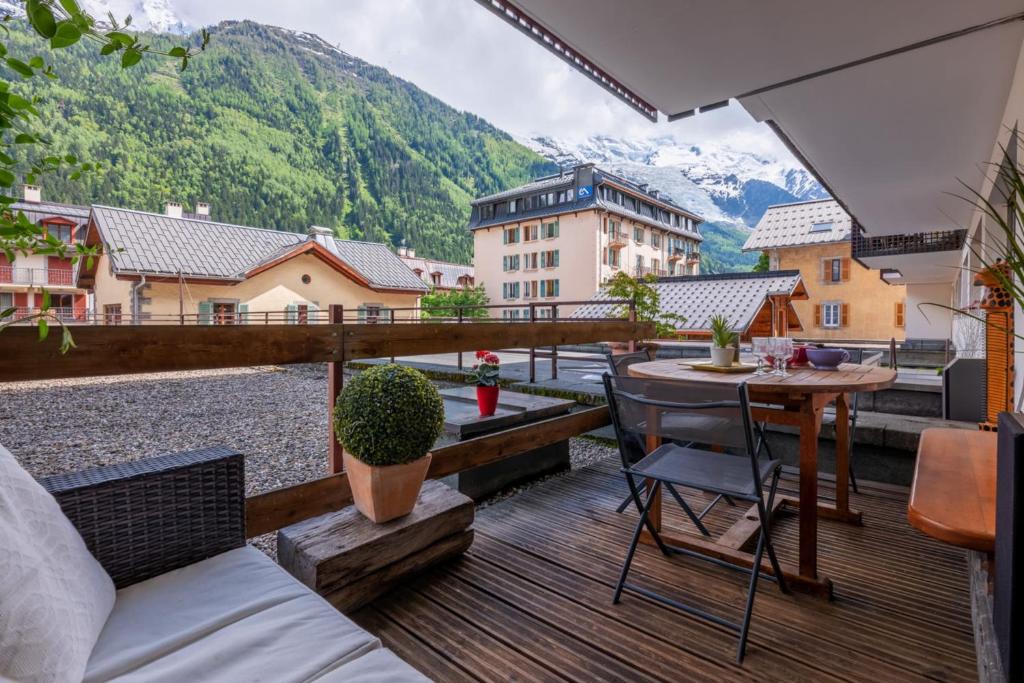 d'un balcon avec une table et une vue sur les montagnes. dans l'établissement In the center of Chamonix with views of Mont Blanc, à Chamonix-Mont-Blanc