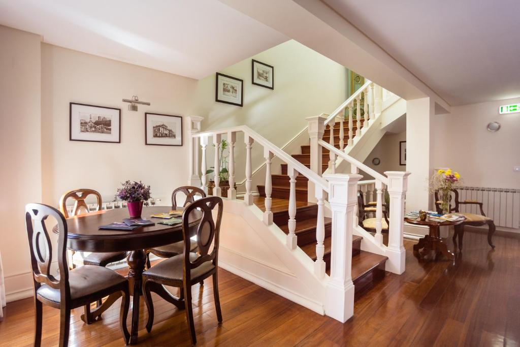 a dining room with a table and a staircase at Old City Guest House in Braga