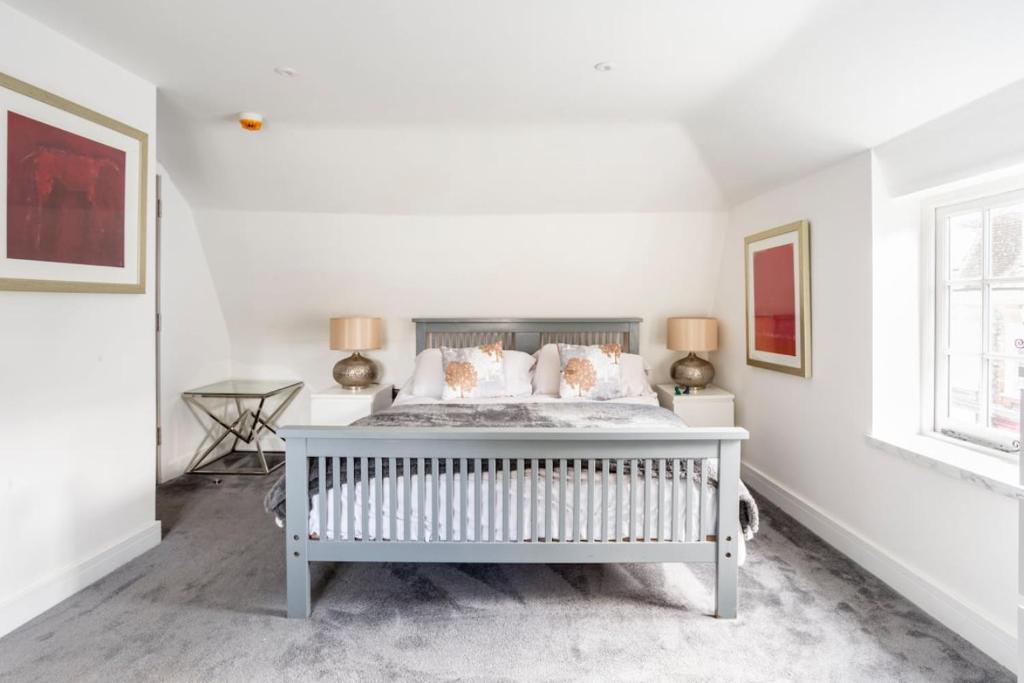 a white bedroom with a bed and two windows at The Secret, Stylish & Spacious En Suite in Blandford Forum, Dorset in Blandford Forum