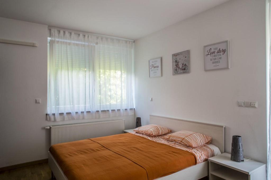 a bedroom with a bed with two pillows and a window at Lakeside Jarun Apartment in Zagreb