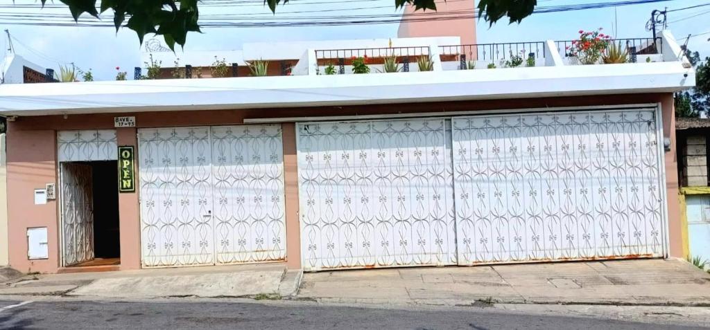 ein Gebäude mit einem weißen Tor auf einer Straße in der Unterkunft Hotel Don Felipe Aeropuerto in Guatemala