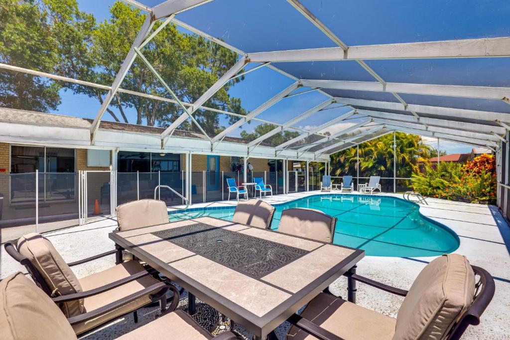 a patio with a table and chairs and a pool at Waterfront Villa with Pool about 5 Mi to Ybor City! in Tampa