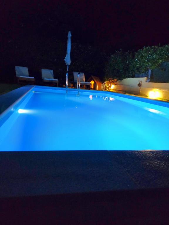 a swimming pool with blue lighting at night at Villa Filoxenia all seasons, near airport, sea, Athens in Aghia Marina