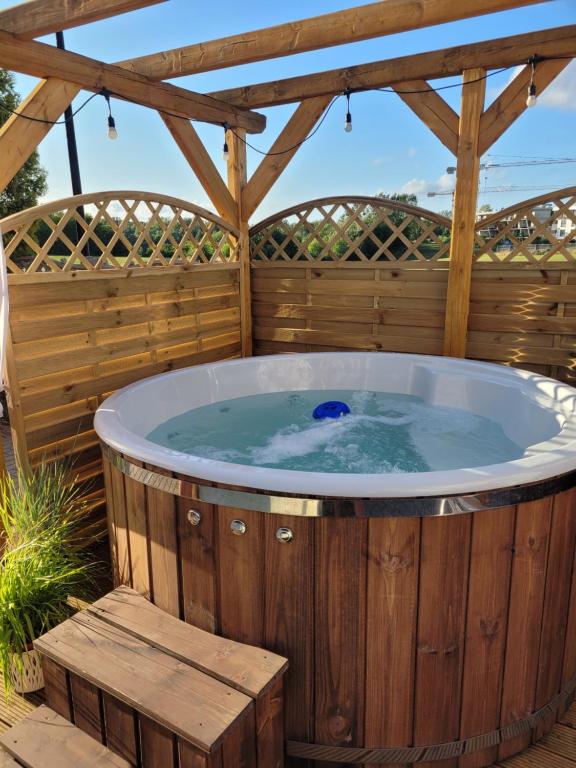 a hot tub in a wooden deck with a pergola at Apartamenty Morski Brzeg - Sauna, Balia in Władysławowo