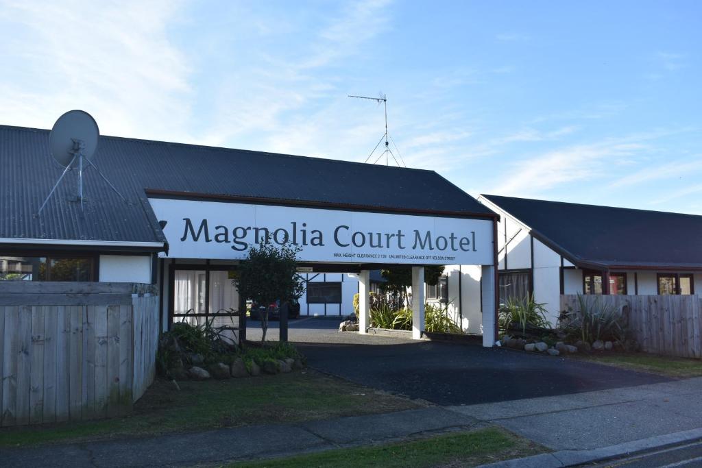 オポティキにあるMagnolia Court Motelの模型を読み取る看板のある建物