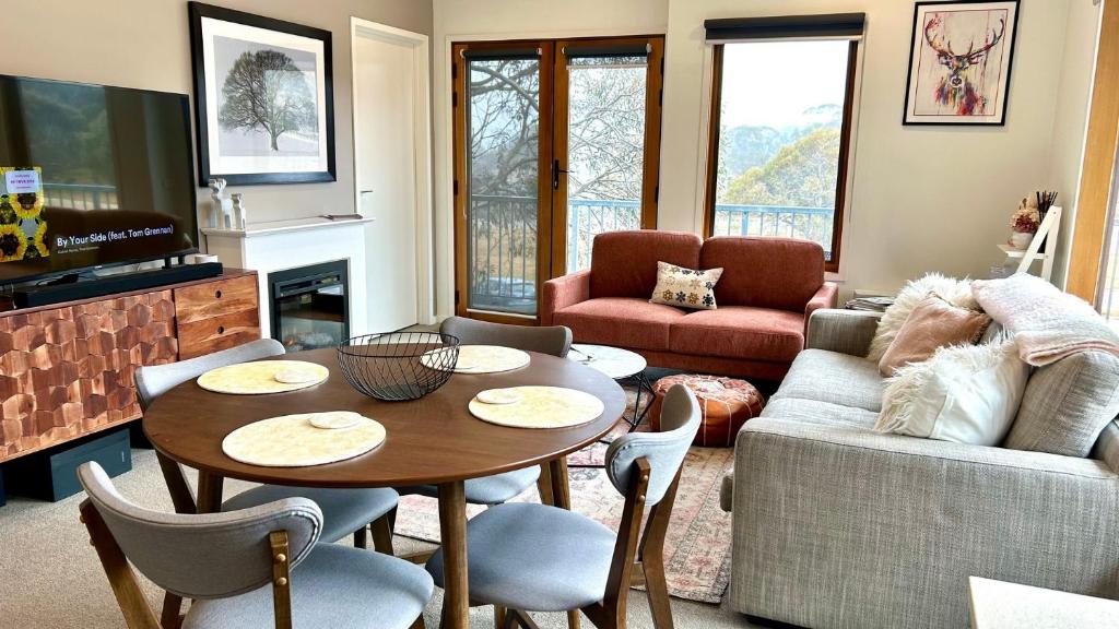 a living room with a table and a couch at Apres in Dinner Plain