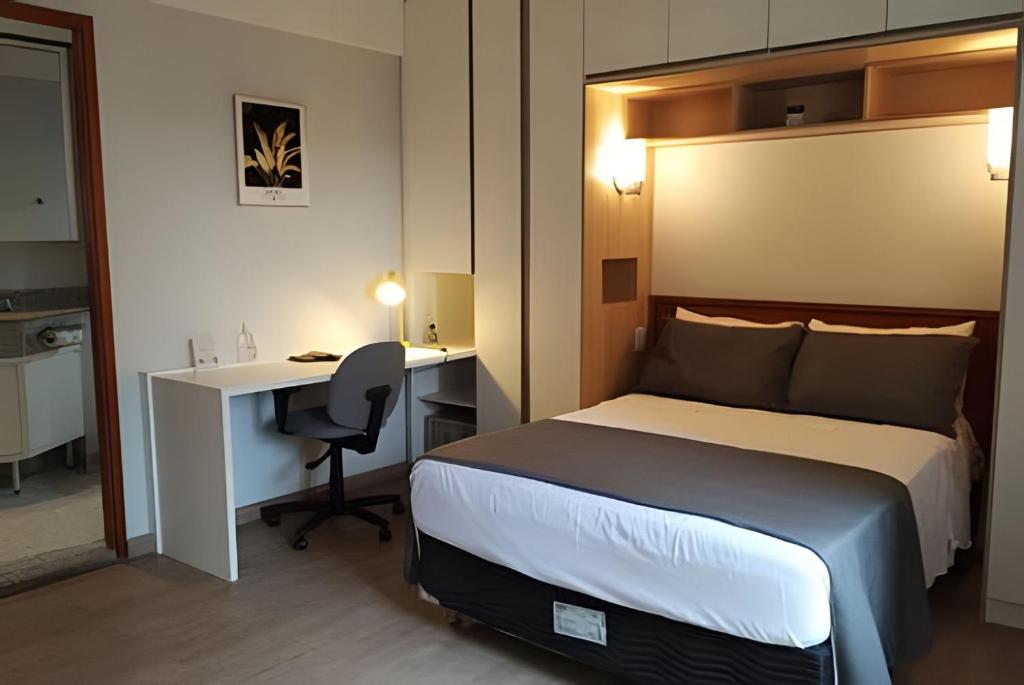 um quarto de hotel com uma cama, uma secretária e um computador em UH 1002 Flat Live Logde Vila Mariana Pq Ibirapuera em São Paulo