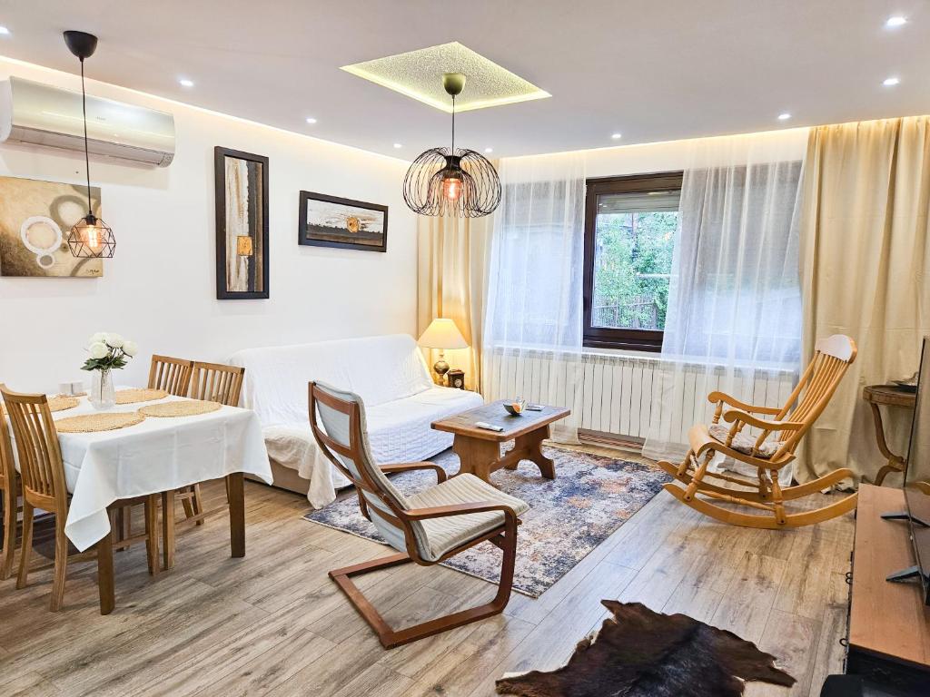 萨拉热窝Ludwigs Apartment Sarajevo的客厅里有一张白色的桌子和椅子