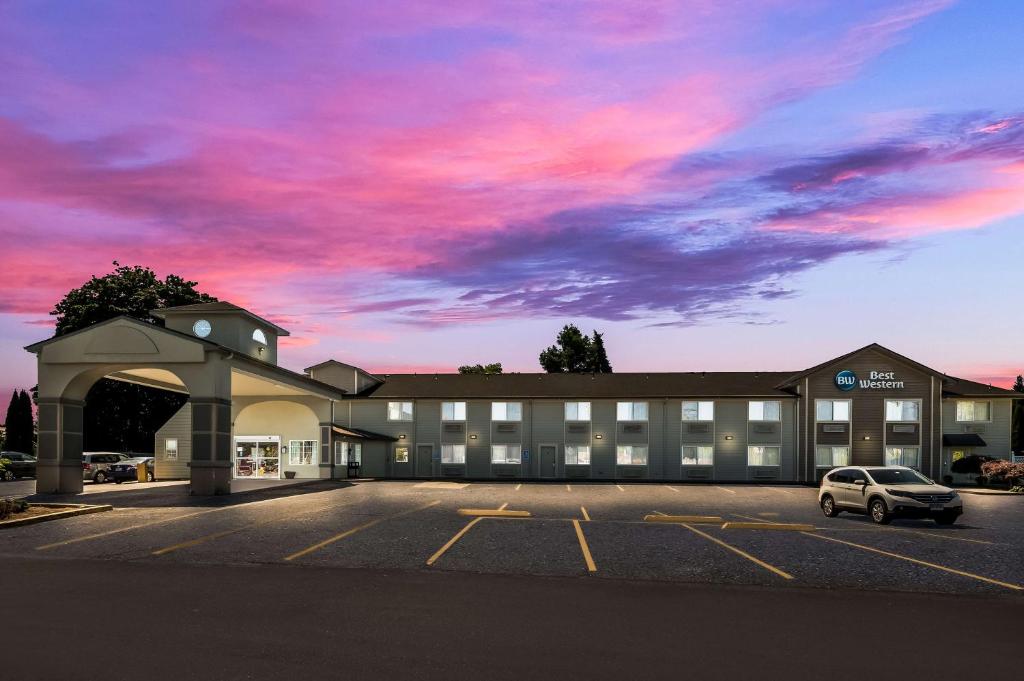 ein Gebäude mit einem auf einem Parkplatz geparkten Auto in der Unterkunft Best Western Cottage Grove Inn in Cottage Grove