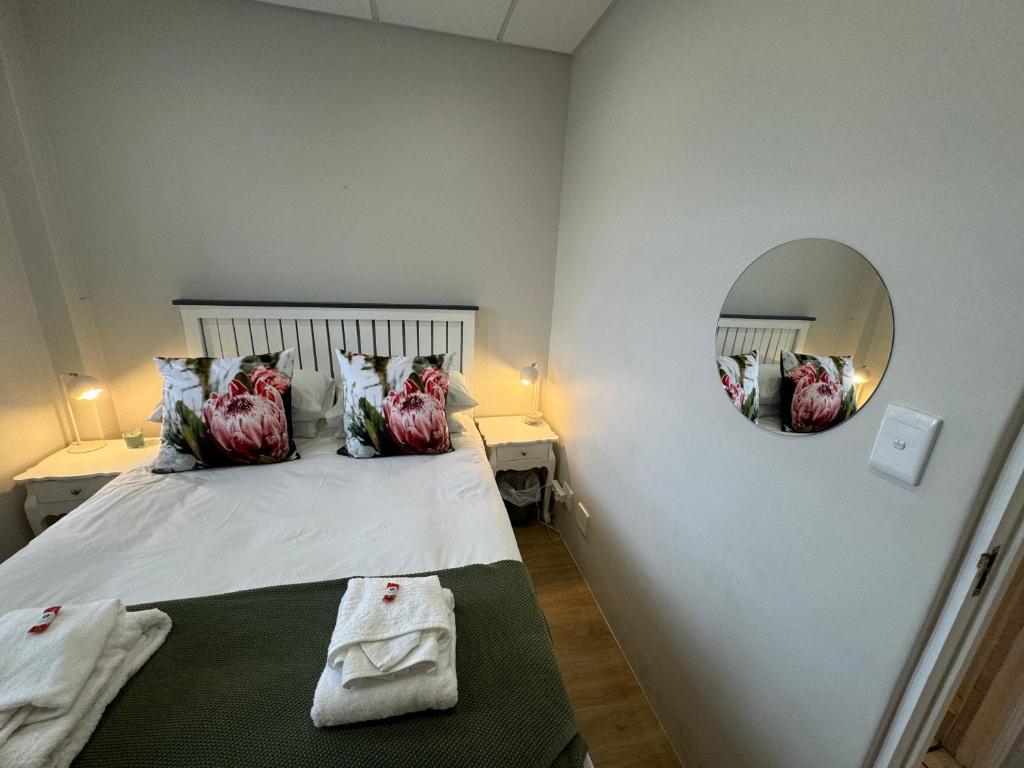 a bedroom with a bed with a mirror on the wall at Protea in Paarl