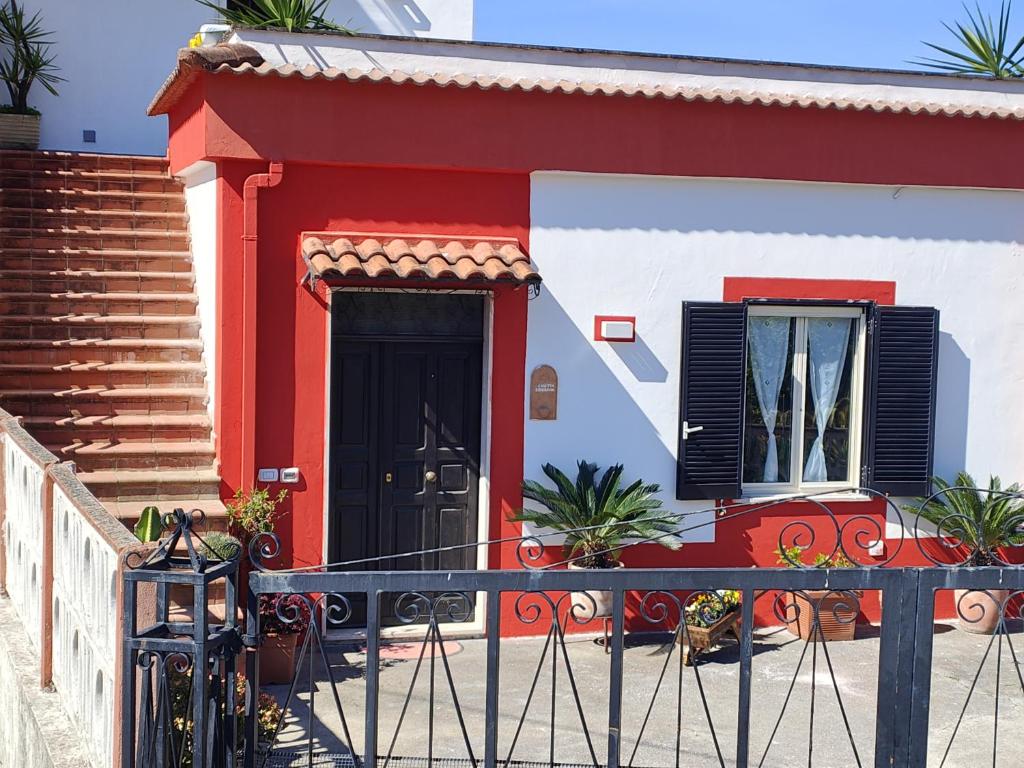 a red and white house with a black door at Casetta Esmeralda in Praia a Mare