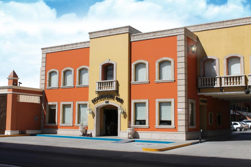 un edificio de color naranja y amarillo en Hotel Plaza las Quintas, en Hermosillo