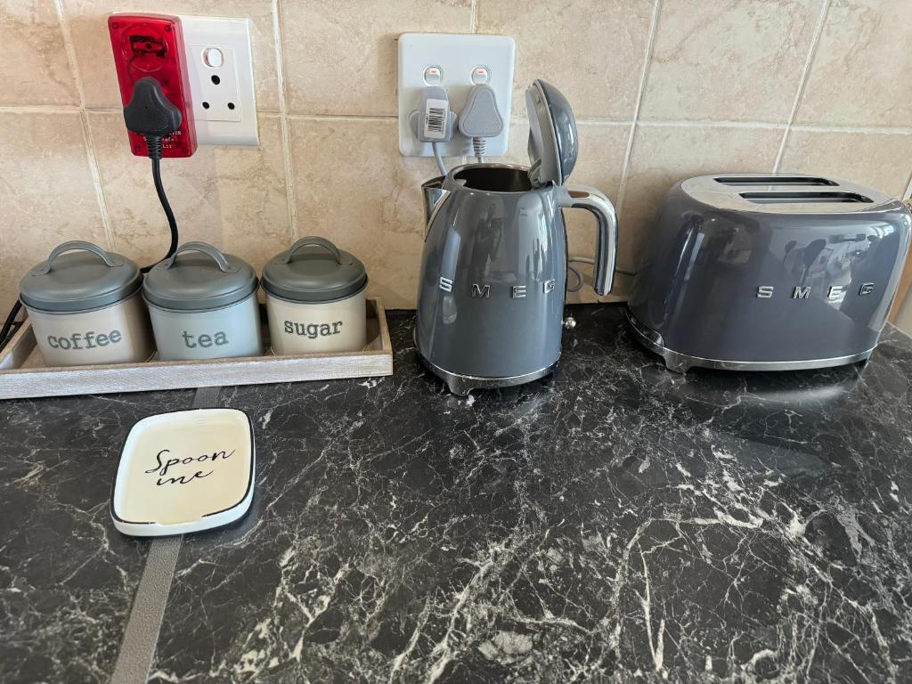 a kitchen counter with two coffee pots and a tea kettle at The Silhouette in Paarl