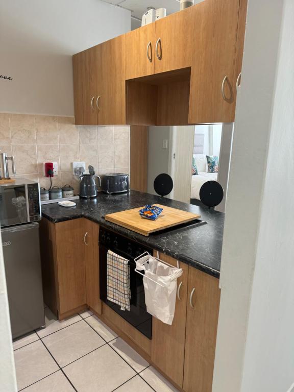 a kitchen with wooden cabinets and a counter top at The Silhouette - Paarl - Self Catering Apartment in Paarl