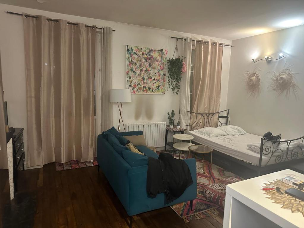 - un salon avec un canapé bleu et un lit dans l'établissement Sacré-Cœur appart atypique, à Paris