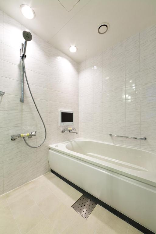 a white bathroom with a tub and a tv at Solaria Nishitetsu Hotel Ginza in Tokyo