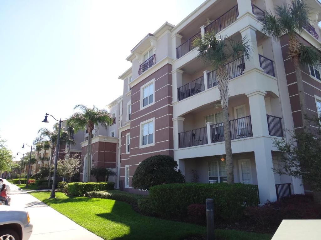 un bâtiment avec des palmiers en face de celui-ci dans l'établissement Universal Studios Area Apartment, à Orlando