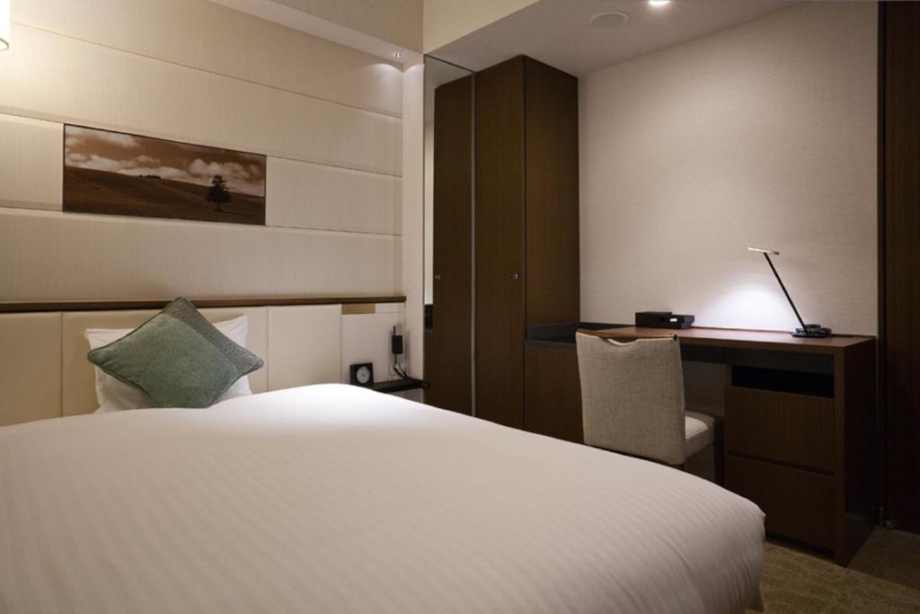 a hotel room with a bed and a desk at Solaria Nishitetsu Hotel Ginza in Tokyo