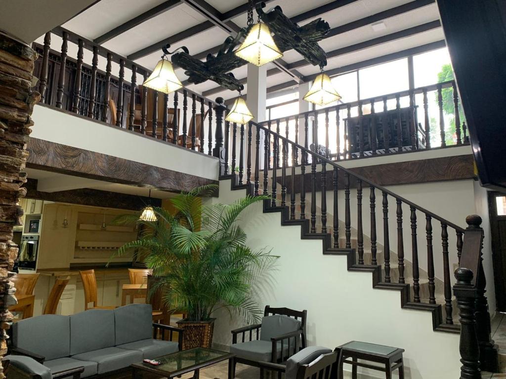 uma sala de estar com uma escada com um sofá e cadeiras em Casa La Riviera em Santa Rosa de Cabal