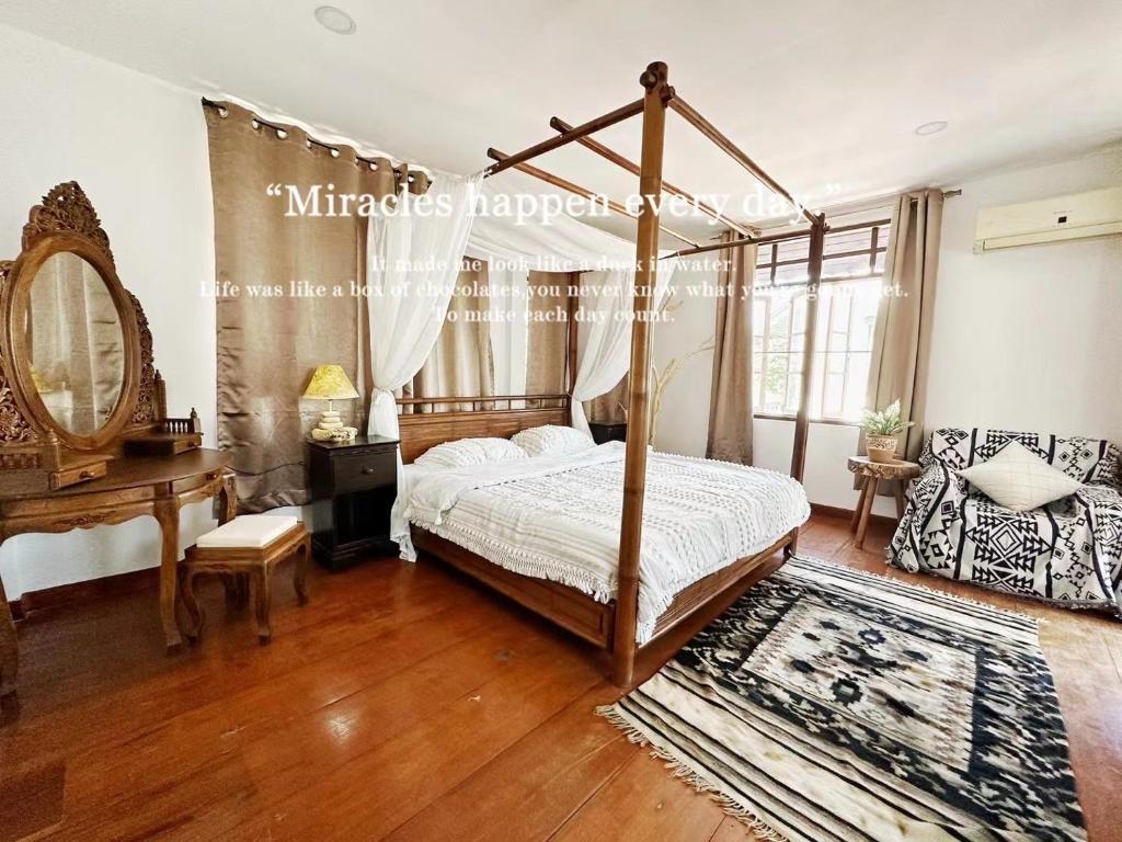 a bedroom with a canopy bed and a desk at An‘s Home in Chiang Mai