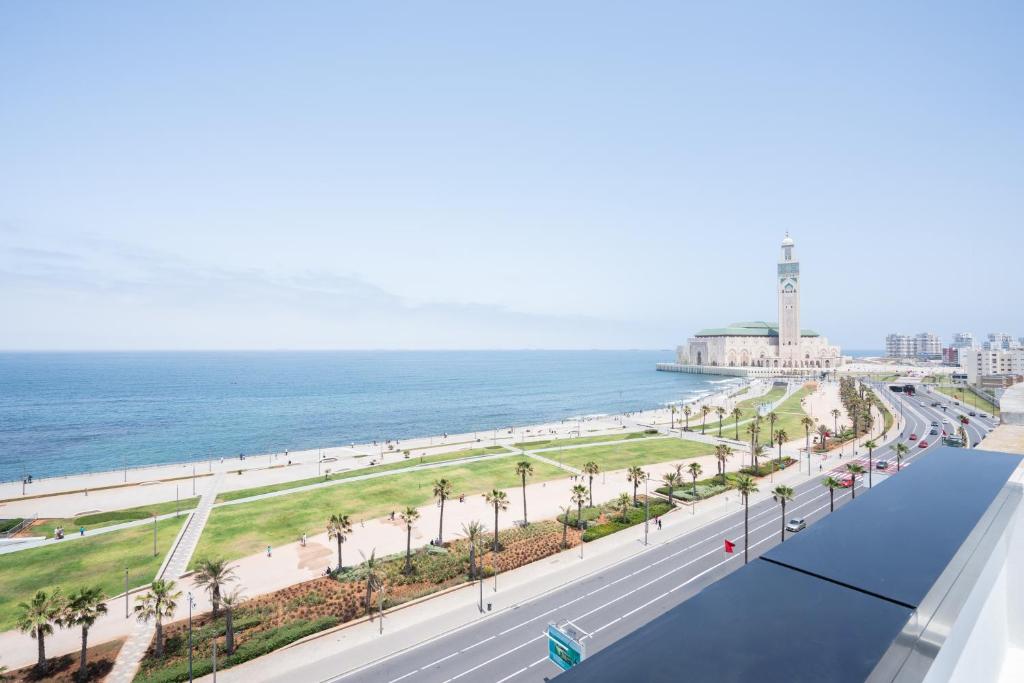 a view of the beach and ocean from the balcony of a building at Atlantic View Appart'Hotel - Mosquée Hassan II in Casablanca
