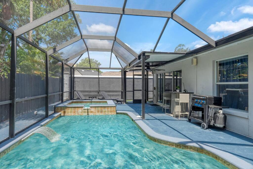 einen Pool in einem Haus mit einem großen Fenster in der Unterkunft Luxury Style townhome with Pool - 1 Miles to Bucs Stadium in Tampa