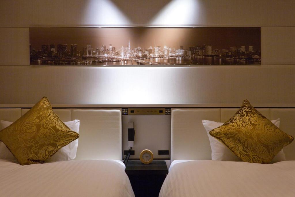 a hotel room with two beds and a picture of a city at Solaria Nishitetsu Hotel Ginza in Tokyo