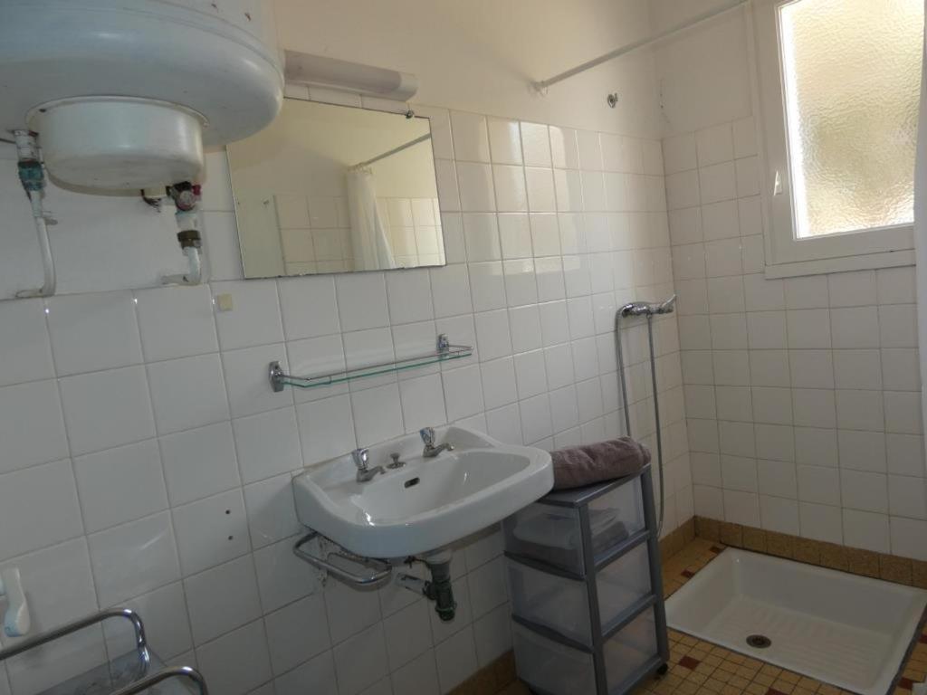 a white bathroom with a sink and a mirror at Appartement Notre-Dame-de-Monts, 2 pièces, 5 personnes - FR-1-540-216 in Notre-Dame-de-Monts