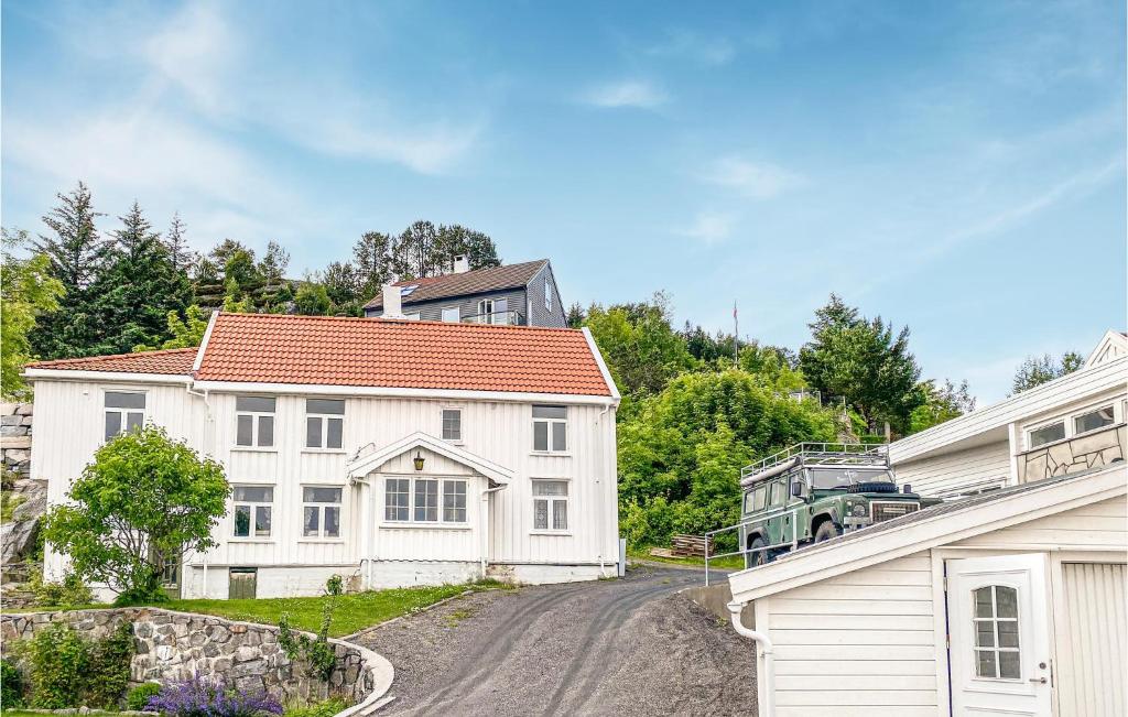 Ein weißes Haus mit einem LKW, der auf einer Straße parkt in der Unterkunft Awesome Home In Kristiansund With House Sea View in Kristiansund