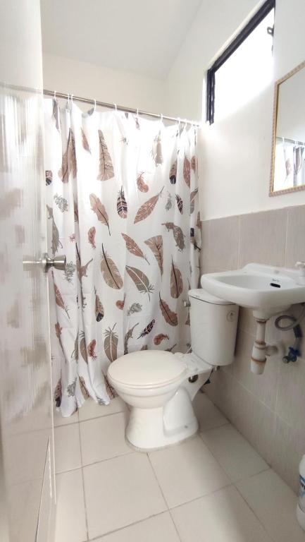 a bathroom with a toilet and a sink and a shower curtain at Olango Transient Home,with WIFI &Netfix in Santa Rosa