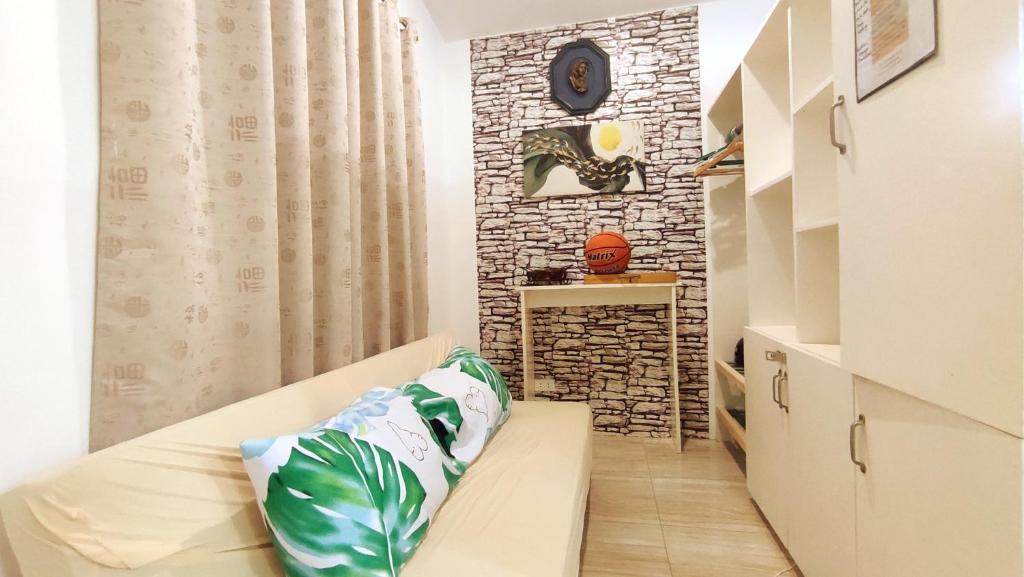 a small room with a couch and a brick wall at Olango Transient Home,with WIFI &Netfix in Santa Rosa