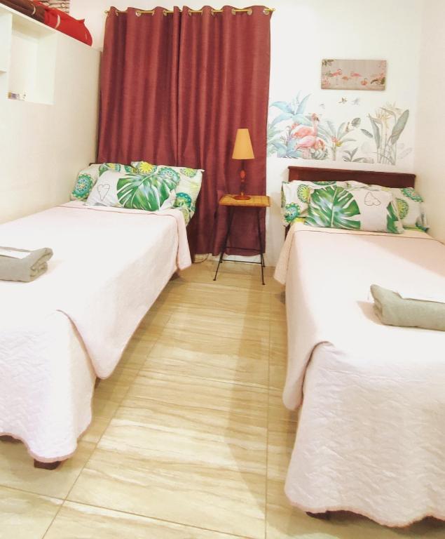 a room with two beds and a table with a lamp at Olango Transient Home,with WIFI &Netfix in Santa Rosa