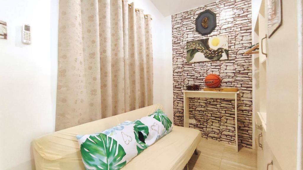 a living room with a couch and a brick wall at Olango Transient Home,with WIFI &Netfix in Santa Rosa