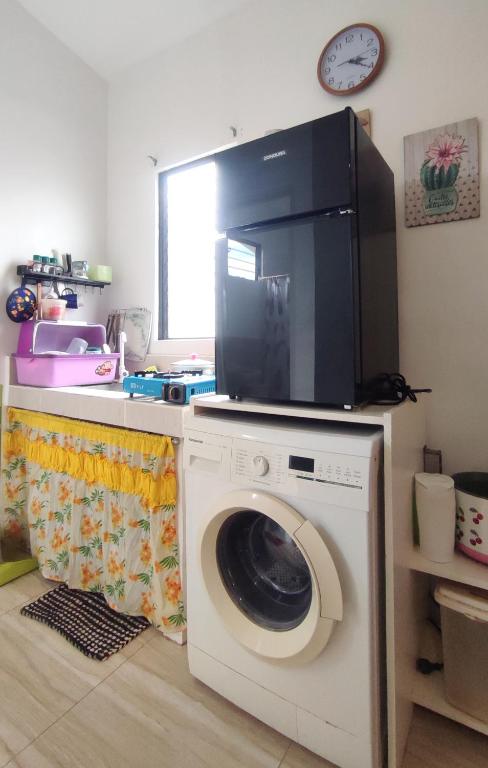 a washing machine with a tv on top of it at Olango Transient Home,with WIFI &Netfix in Santa Rosa