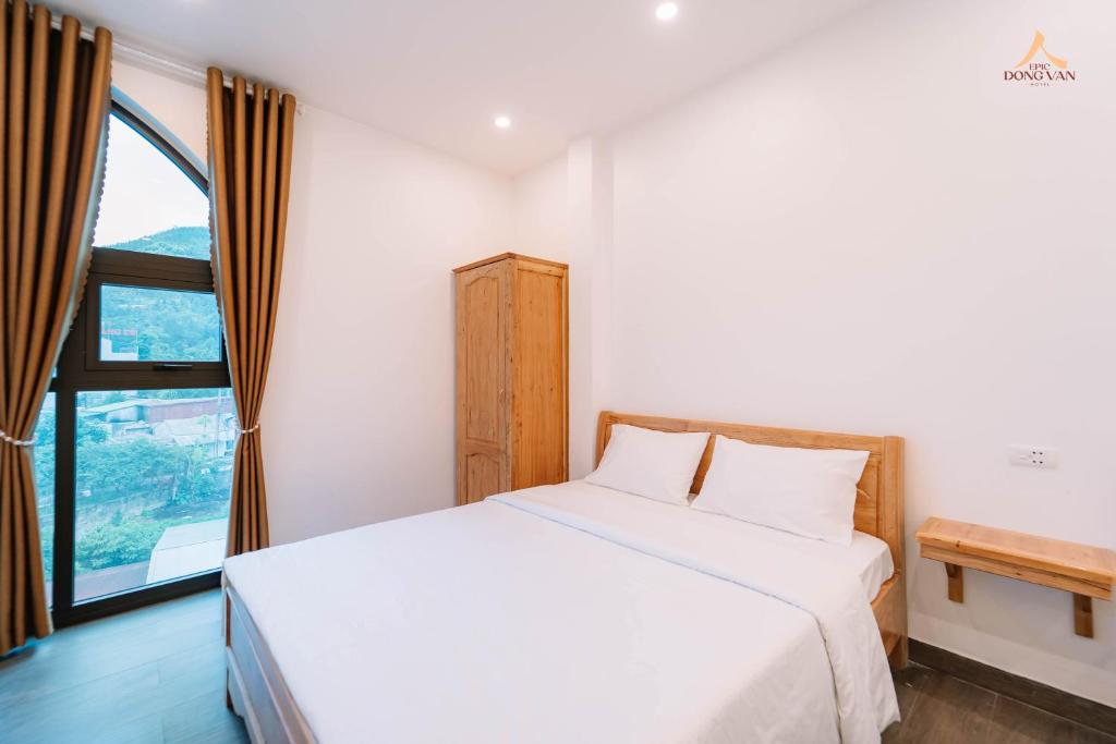 Postel nebo postele na pokoji v ubytování Epic Đồng Văn Hotel