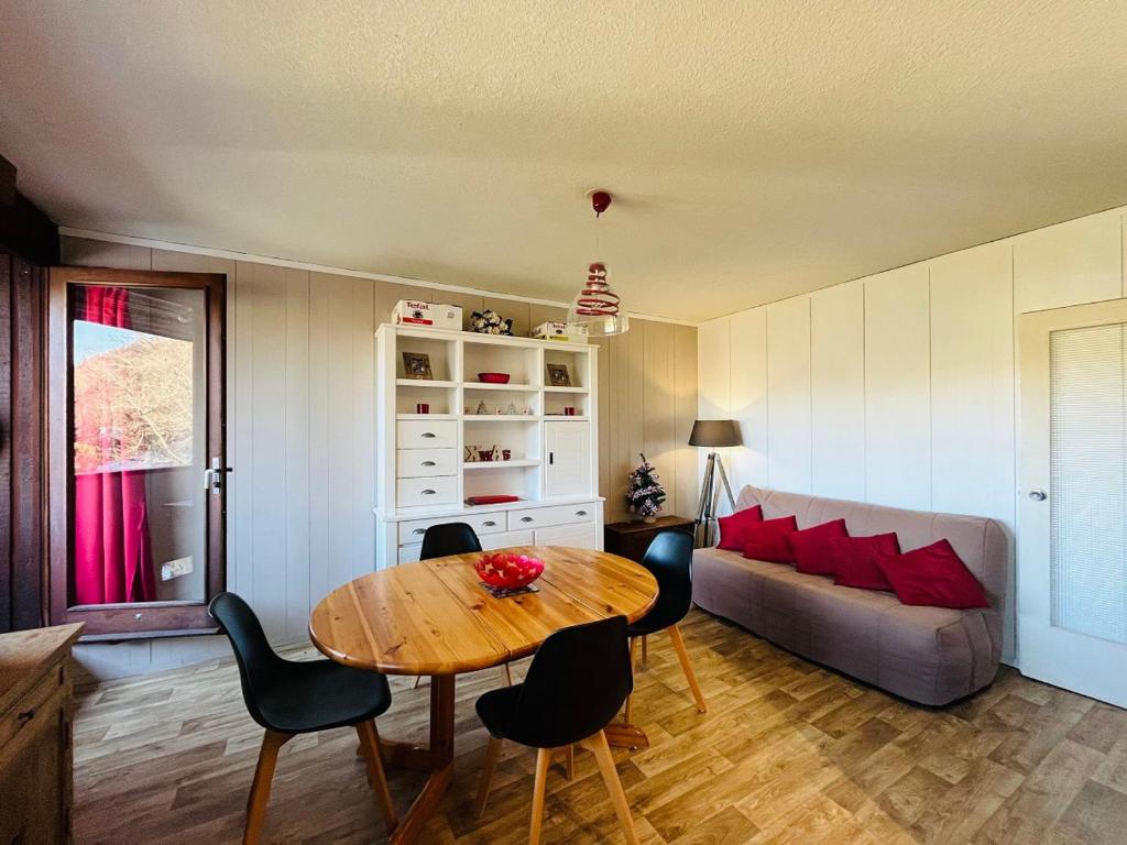 ein Wohnzimmer mit Tisch und Couch in der Unterkunft Appartement au Mont-Dore - 2 pièces, 34m², loggia et parking, proche centre et Thermes - FR-1-608-257 in Mont-Dore